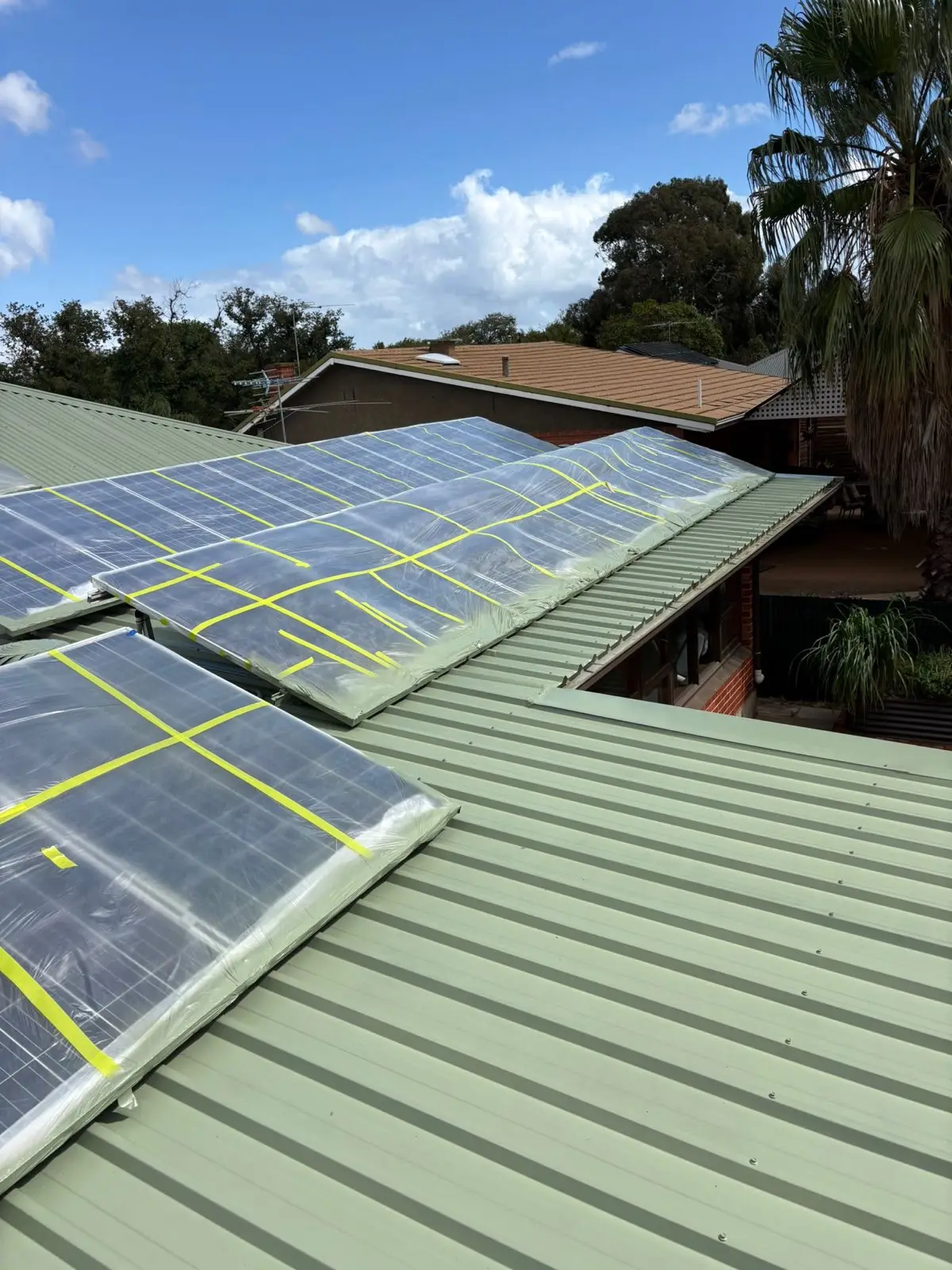New metal roof with solar panels protected under wrapping during works