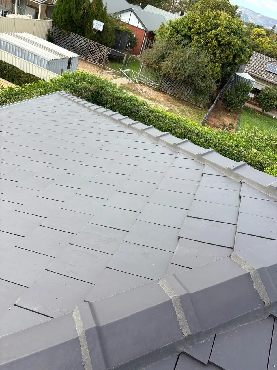 Freshly re-pointed ridge capping on a coated tile roof